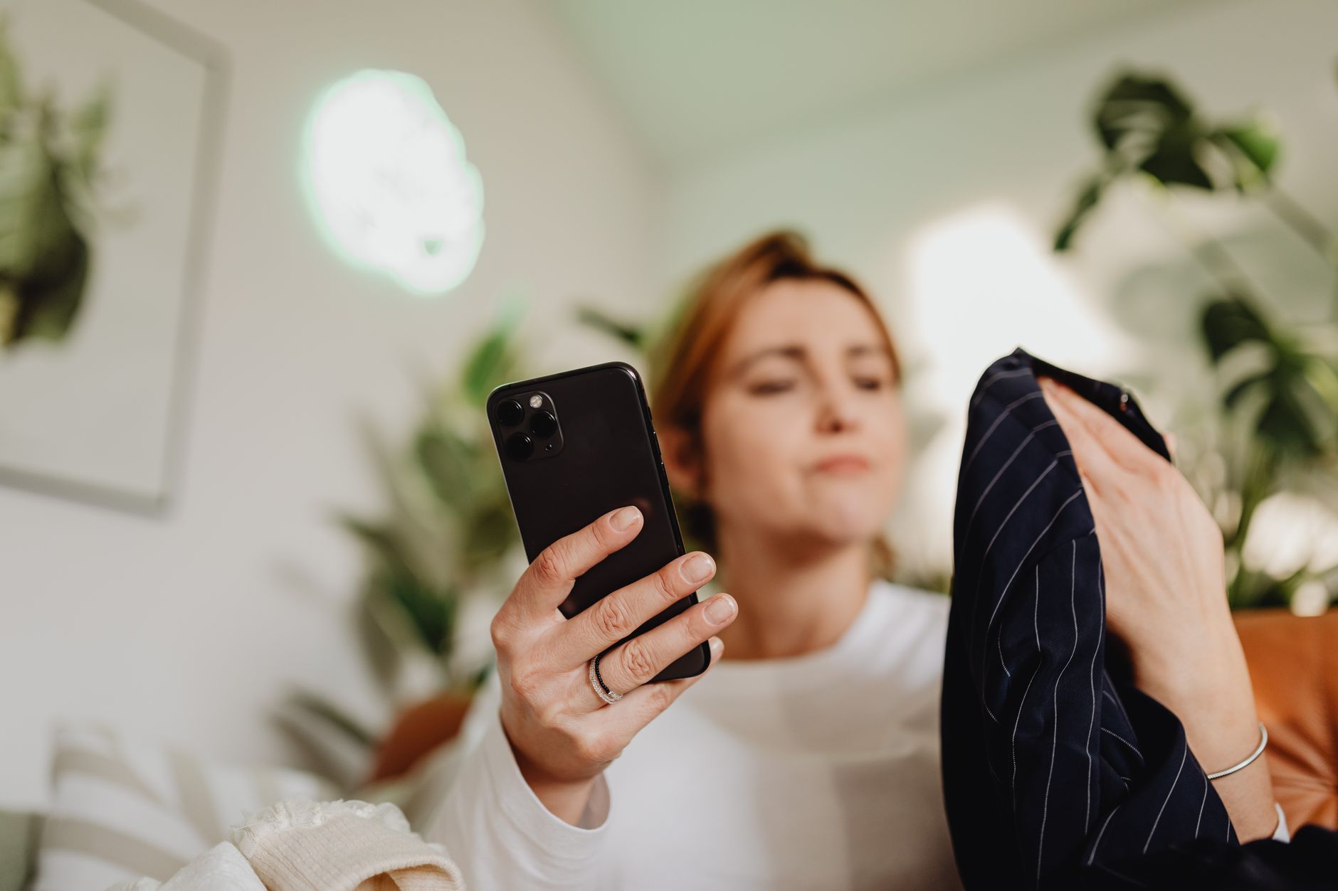 Woman using AI styling tools on her phone while browsing fashion online